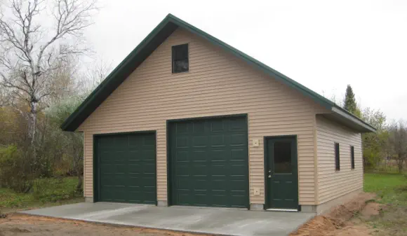 vinyl sided garage with two large doors and a service door - Construction in Upper Peninsula of Michigan