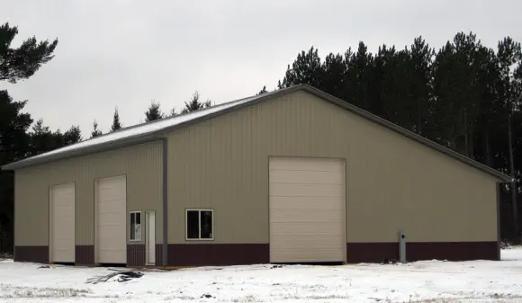 Pole barn construction with steel siding and three large doors - Construction in U.P. of Michigan