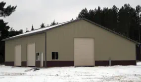 Pole barn construction with steel siding and three large doors - Construction in U.P. of Michigan