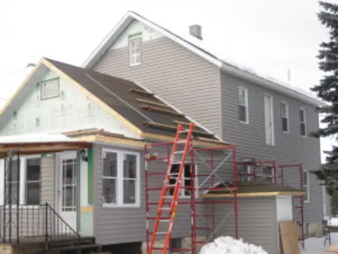 New from porch addition to house with gray siding