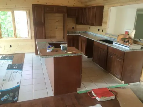 kitchen in progress with dark wood cabinets and black and white granite countertop