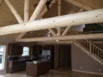 interior of open concept house with log beams