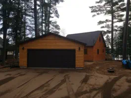New garage with log siding and double stall garage doors
